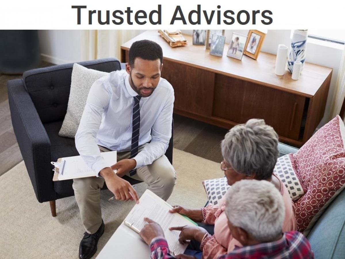 A financial advisor discussing the benefits of a reverse mortgage with his senior clients.